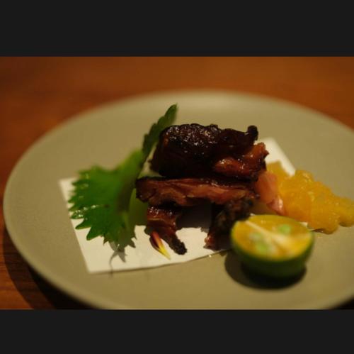 a plate of food with meat and fruit on a table at Rakuhotel in Wenzhou