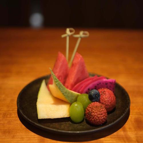 a plate of food with fruit on a table at Rakuhotel in Wenzhou