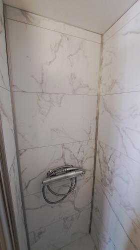 d'une douche avec un mur en marbre blanc. dans l'établissement Magnifique t2 duplex vue port, au Cap d'Agde