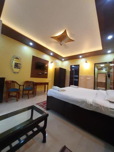 a hotel room with a large bed and a table at Aloha Rishikesh India Apartment by Nibhachi in Rishīkesh