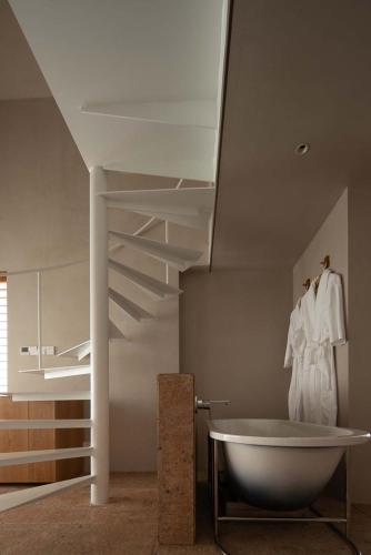 a bathroom with a bath tub and a staircase at Rakuhotel in Wenzhou