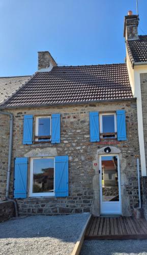 une maison en briques avec des volets bleus et une porte dans l'établissement Jolie maison de campagne, à Rauville-la-Place