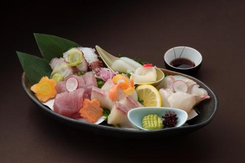 a bowl filled with different types of food on a table at GRANDVRIORESORT ISHIGAKIJIMA Ocean's Wing & Villa Garden in Ishigaki Island