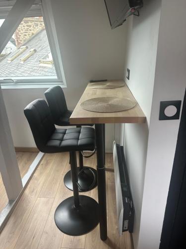 une petite cuisine avec une table et une chaise dans l'établissement Petit cocon avec petite vue mer, à Dinard