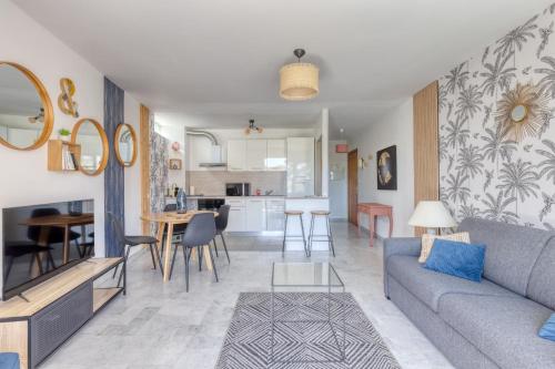 un salon avec un canapé et une cuisine dans l'établissement T2 - Les Dauphins, Bord de mer, à Saint-Raphaël