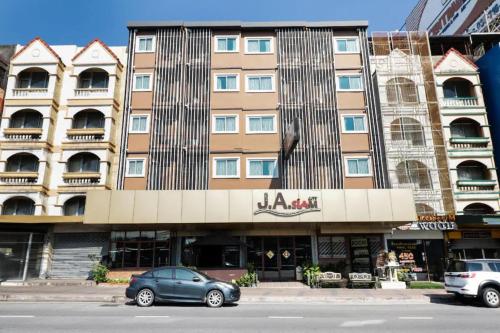 a building with a car parked in front of it at Dancenter JA Siam City in Pattaya