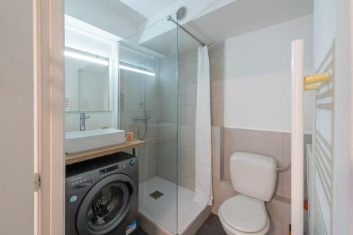 une salle de bain avec une machine à laver et un lavabo dans l'établissement Very nice apartment in downtown Mulhouse Kennedy, à Mulhouse