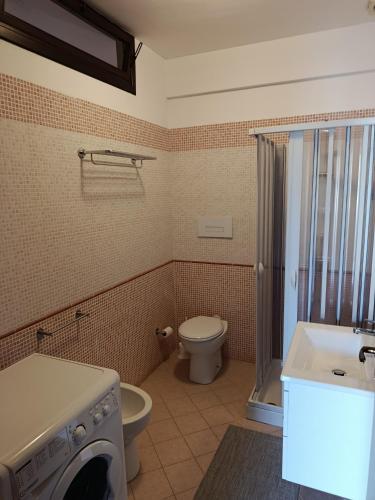 a bathroom with a toilet and a sink and a washing machine at Relax beach San Vito lo Capo in San Vito lo Capo