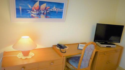 a desk with a television and a lamp on a desk at Hotel Am Kurpark in Malente