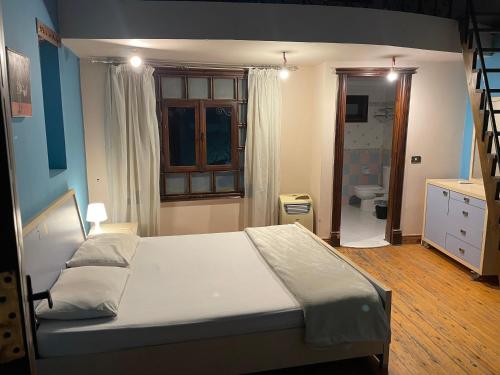a bedroom with a large bed and a bathroom at Standalone Villa in Cairo