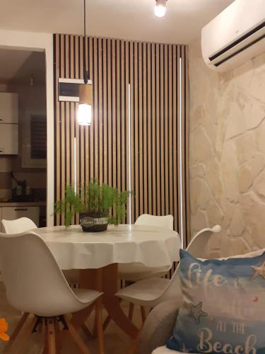 a dining room with a white table and chairs at Villa PANORAMA in Pag