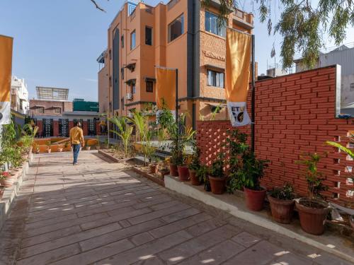 a person walking down a sidewalk next to a building at The Hosteller Jodhpur in Jodhpur