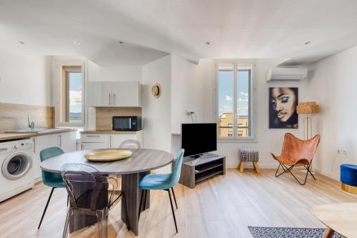 une cuisine et un salon avec une table et des chaises dans l'établissement T2 -Le Winter Palace, Vue Mer, à Saint-Raphaël