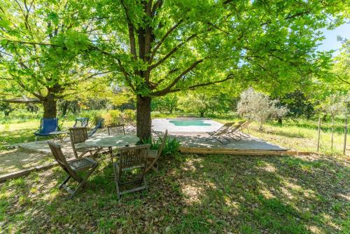 a patio with a table and chairs under a tree at Maison Monteux in Monteux
