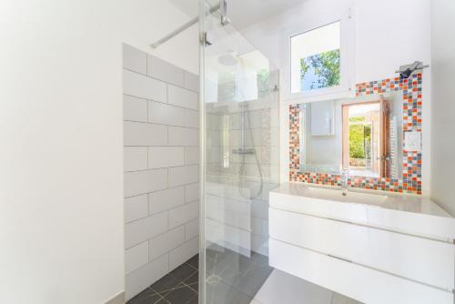 a white bathroom with a sink and a mirror at Maison Monteux in Monteux