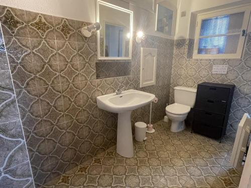 une salle de bain avec un lavabo et des toilettes dans l'établissement 88m2 - piscine - parking - maison provençale 3 chambres, à Roquebrune-sur Argens