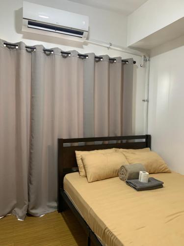 une chambre avec un lit avec un rideau et une fenêtre dans l'établissement Netflix & Chill at Pablo's Homestay-Grace Residences Tower 4, à Manille