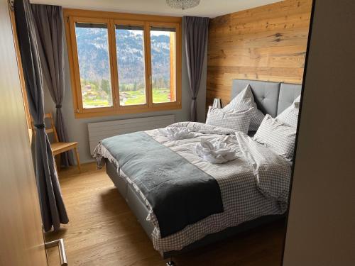 a bedroom with a large bed with a window at Alp n' rose in Hasliberg