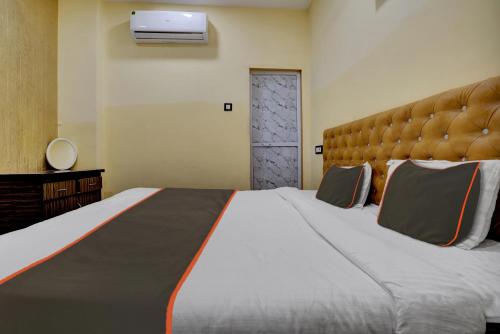 a bedroom with a large bed with a large headboard at Super Hotel O Golden Suites in Turambhe