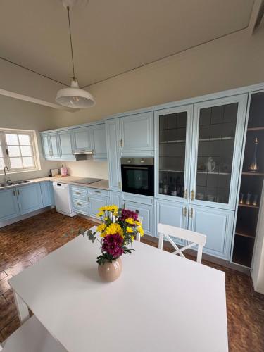 una cucina con tavolo bianco e fiori di Linear Flat - City Center - Private Parking a Chania