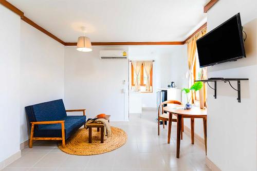 a living room with a blue chair and a table at Dancenter Howard Square Boutique Hotel in Bangkok