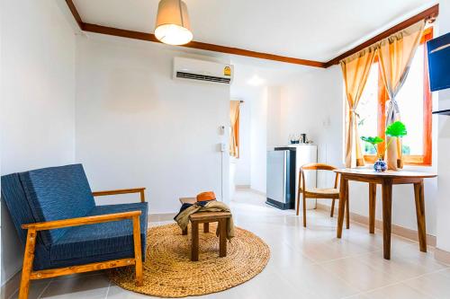 a living room with a blue chair and a table at Dancenter Howard Square Boutique Hotel in Bangkok