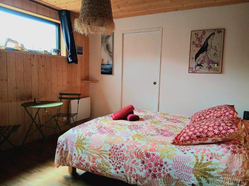 a bedroom with a bed and a table and a window at Chambre paisible avec jardin à la campagne en Finistère sud in Scaër