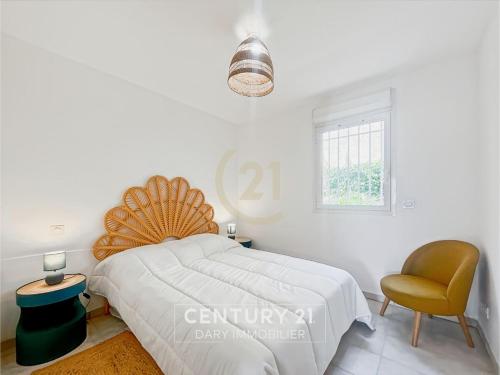 une chambre blanche avec un lit et une chaise dans l'établissement Calvi T2 les Jasmins proche centre, à Calvi