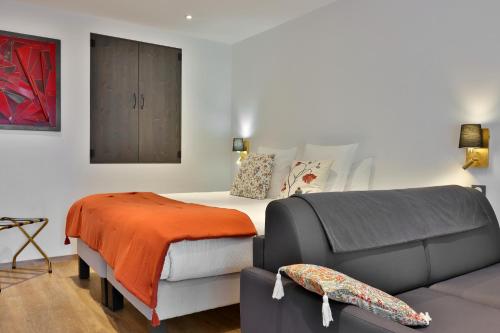 a living room with a bed and a couch at Boutique-Hôtel Restaurant L'Atelier d'Epicure Logis in Castels