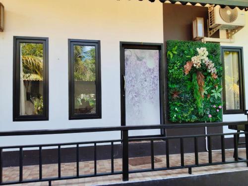a wall with four windows with flowers on it at Maidok Homestay(ไม้ดอกโฮมสเตย์) in Ban Pak Ba Ra