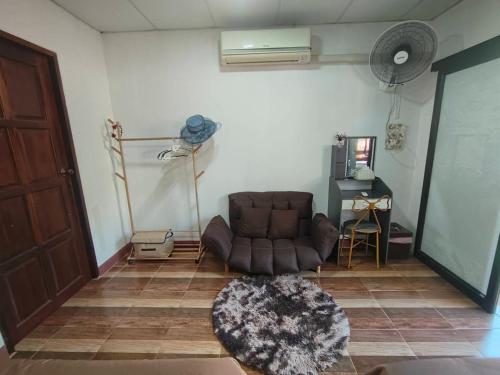 a living room with a leather chair and a table at Maidok Homestay(ไม้ดอกโฮมสเตย์) in Ban Pak Ba Ra