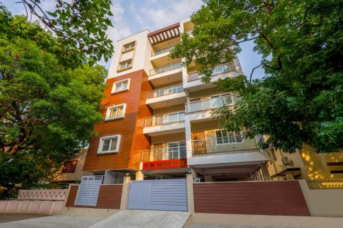a tall apartment building with trees in front of it at Sliceinn Sylva, Wilson Garden, Bangalore in Bengaluru