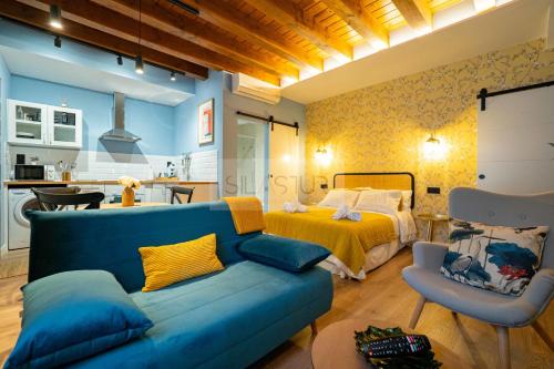 a living room with a blue couch and a bed at Casina de Santa Ana I By Silastur in Siero