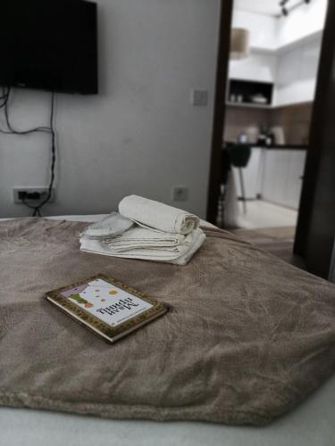 a bed with a blanket and towels on it at Apartmani Zoe, Jagodina, Aqvapark, K-kompleks in Trnava