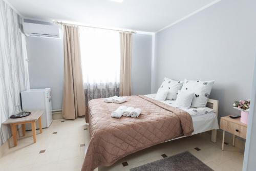 a bedroom with a bed with two towels on it at Перлина Карпат in Pistyn