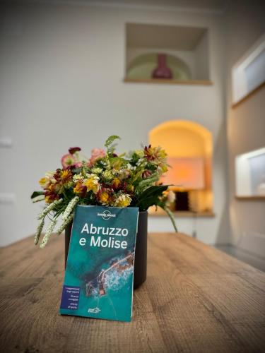 a book sitting on top of a table with a bouquet of flowers at Casa Abbì nel cuore del Molise Molise in Roccasicura