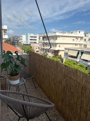una sedia seduta su un balcone con una pianta di Linear Flat - City Center - Private Parking a Chania