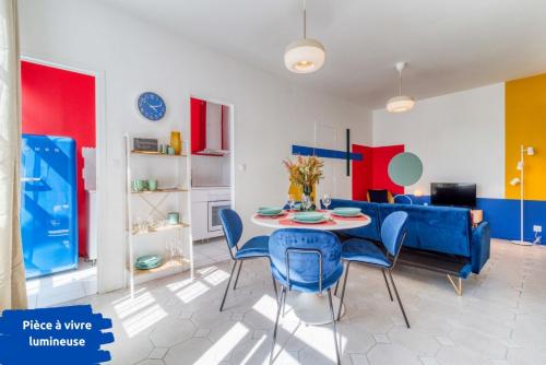 un salon avec un canapé bleu, une table et des chaises dans l'établissement L'Espace Pop - Confort - Calme - Atypique, à Douai