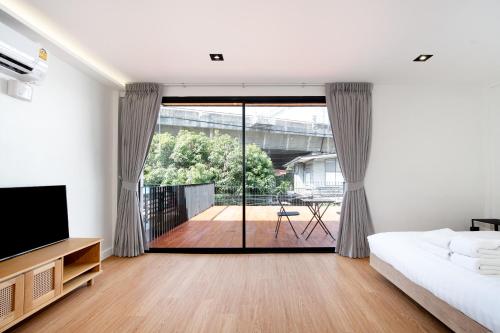 a bedroom with a bed and a sliding glass door at Townhouse in Khet Phayathai - Ari in Bangkok