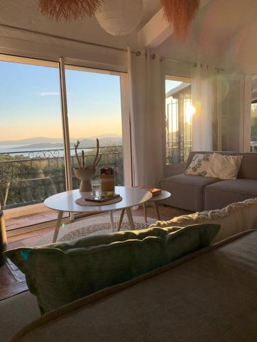 un salon avec une table et une grande fenêtre dans l'établissement Villa de charme 4 chambres vue mer imprenable, à Roquebrune-sur Argens