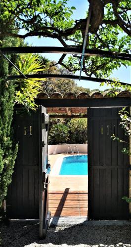 un garage noir avec une piscine derrière dans l'établissement Villa de charme 4 chambres vue mer imprenable, à Roquebrune-sur Argens