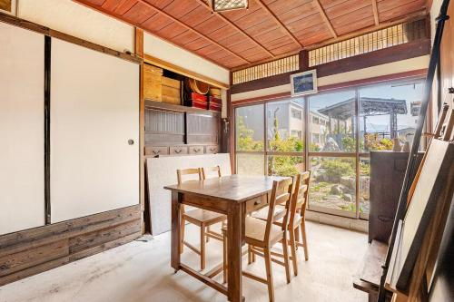 a dining room with a wooden table and chairs at メモリア近江 in Nagahama