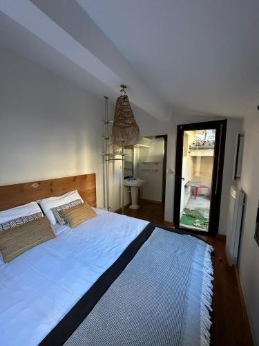 une chambre avec un grand lit et un miroir dans l'établissement Le Petit Camisou, un écrin au pied de la Cité, à Carcassonne