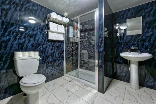 a bathroom with a toilet and a shower and a sink at Grainger Hotel in Newcastle upon Tyne