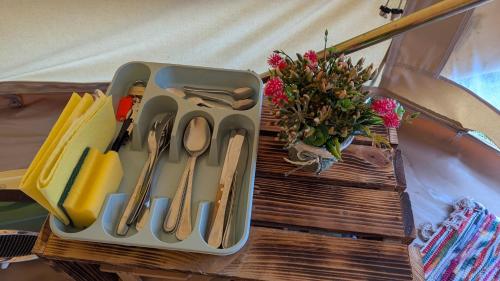 a tray with utensils and a vase of flowers on a table at Camping Solau in Espot
