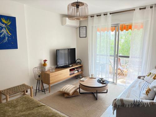 un salon avec une télévision et un canapé dans l'établissement Les Lavandes, à Sanary-sur-Mer