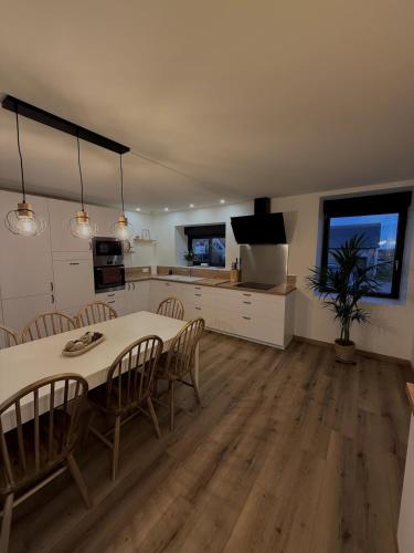 une cuisine et une salle à manger avec une table et des chaises dans l'établissement Gîte de la Rosaline, à Saint-Jacques-de-Néhou