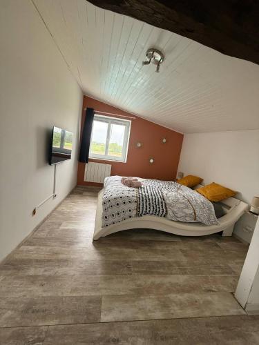 une chambre avec un grand lit dans un grenier dans l'établissement Nid paisible avec un coin terrasse, à Faramans