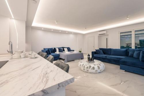 a large living room with blue couches and a table at Sea Breeze Retreat with Private Pool in Saronida