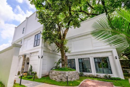 a white house with a tree in front of it at Hotel Seoul in Clark